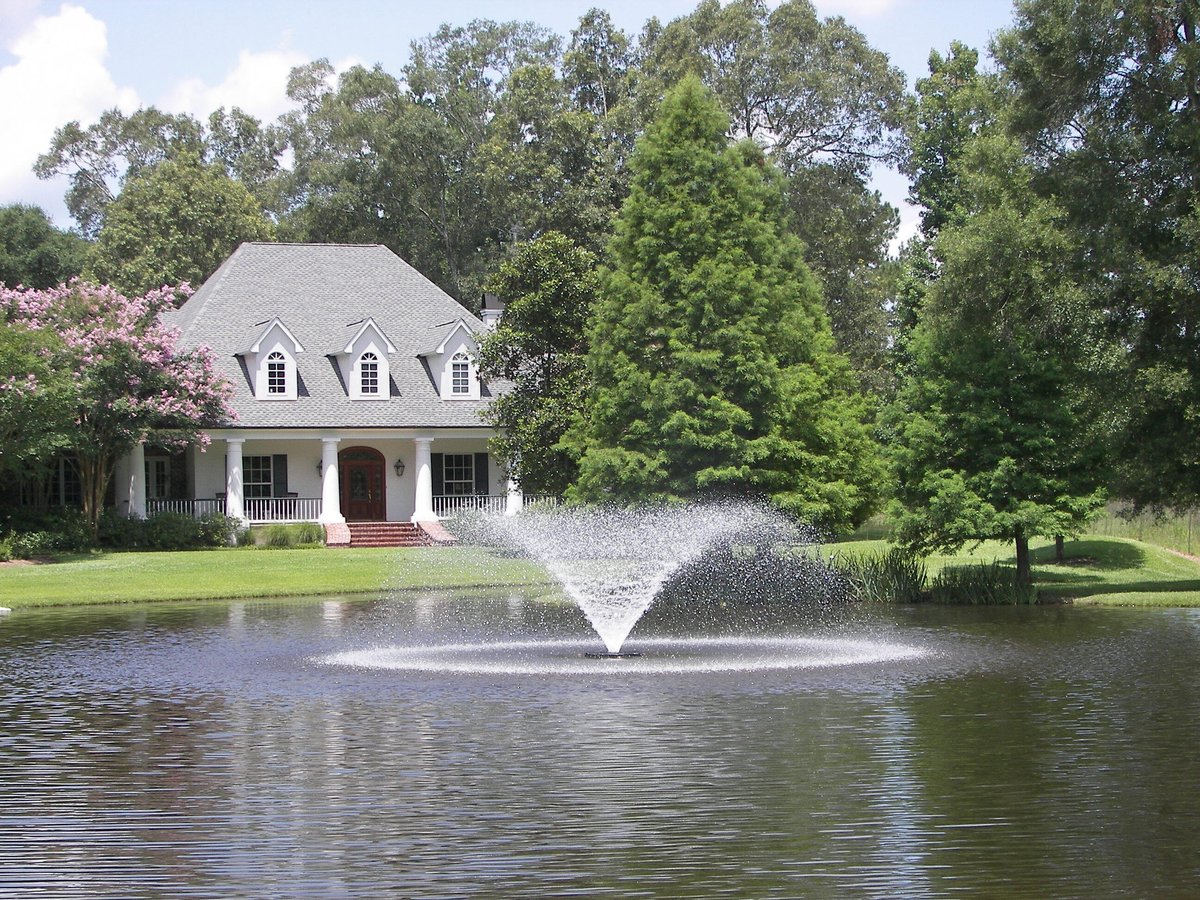 Fountain in Pond with House